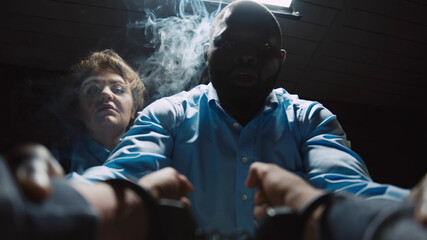 Aggressive cops interrogating suspect shaking violently his hands