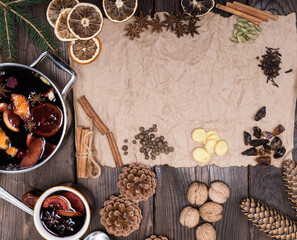 ingredients for making mulled wine on a wooden table and a piece of brown paper