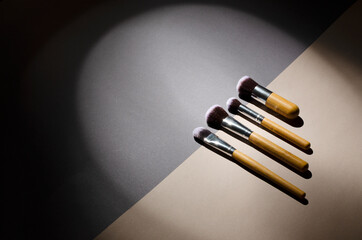 Line of beauty brushes on the grey and beige backgroud, hard show light 