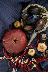 Still life with dried fruits, vegetables and herbs on dark grey textured background. Top view photo of different objects. Colors of autumn.