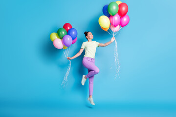 Fototapeta na wymiar Full length body size photo of childish girl jumping high with piles of colorful balloons smiling isolated on vibrant blue color background