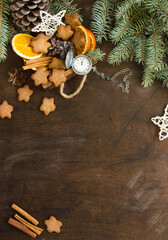 Handmade Christmas decorations and branches of a Christmas tree on a wooden table. Template for design in eco style. Christmas background with fir tree, gingerbread cookies, Christmas toys