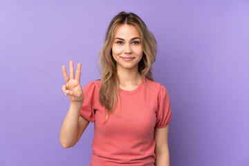 Fototapeta na wymiar Teenager Russian girl isolated on purple background happy and counting three with fingers