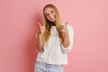 Cheerful beautiful girl showing thumbs up and smiling