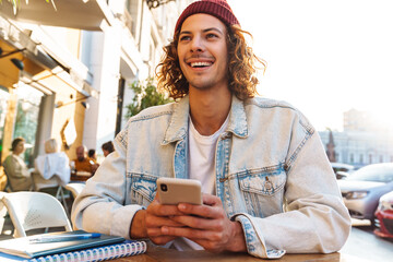 Positive young curly man holding credit card