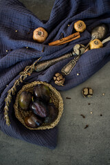 Naklejka premium Simple composition still life with dried fruits, flowers and herbs. Autumn mood photo. Blue textured fabric background. 