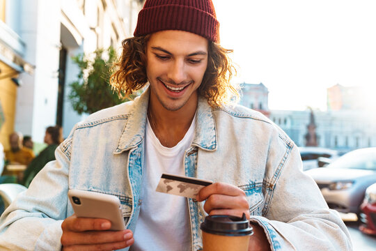 Man Sitting In Cafe While Holding Credit Card