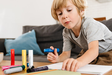 Concentrated little boy drawing at home
