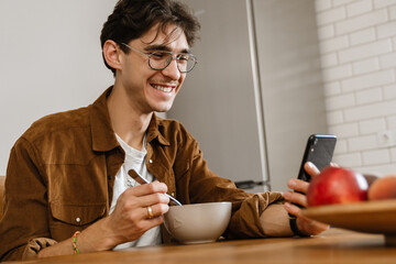 Cheery optimistic handsome man having a breakfast