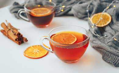 Cup of tea with lemon and cinnamon on white table. Cozy autumn composition