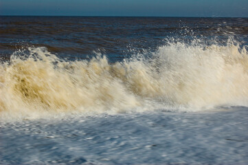 Dramatic Waves breaking on the shore. UK Norfolk coastline.