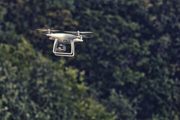 An aerial drone with a camera flies and shoots video over the forest