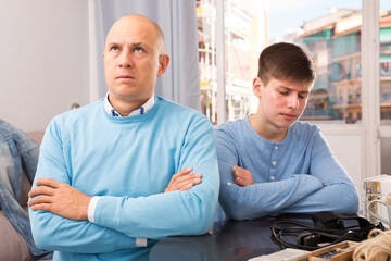 Portrait of man and his teenage son offended at each other