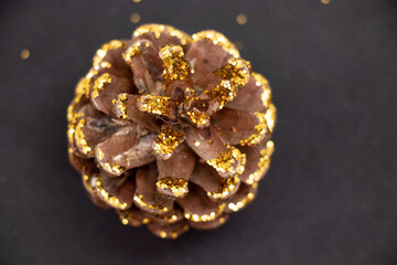 Cones covered with sparkles on a black background. Holidays.