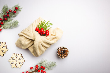 Zero waste gift wrapping traditional Japanese furoshiki style. Plastic free hand made gift package for Christmas with christmas decorations, top view