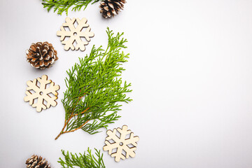 Christmas and New Year background with thuja branch and wooden snowflakes. Flat lay, top view. Place for text. Zero waste, plastic free concepts