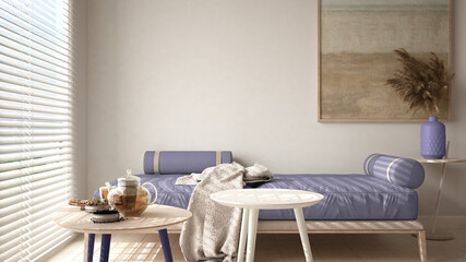 Cosy wooden sustainable living room in purple tones with modern sofa with blanket and coffee tables. Tea time, glass teapot and teacup, snacks. Environmental friendly interior design