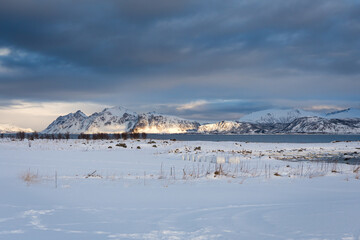 Fototapeta na wymiar Rising sun reflected in the snowy mountains