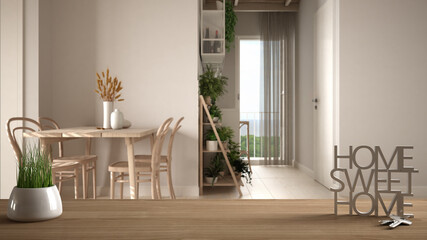Wooden table, desk or shelf with potted grass plant, house keys and 3D letters home sweet home, over cosy dining and living room, architecture interior design, copy space background