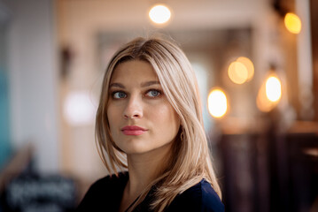Rubbing a beautiful blonde business woman in the interior of a coffee shop with a dim light
