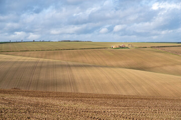 View of farm across ploughed field