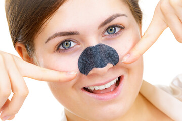 Woman applying pore strips on nose