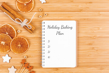 Holiday baking to do list. Spiral notebook on wooden background with decorations. Flat lay