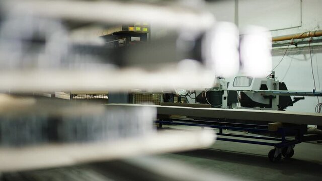 Person cutting metal profiles with buzzsaw in big warehouse/workshop 4k PRORES Footage