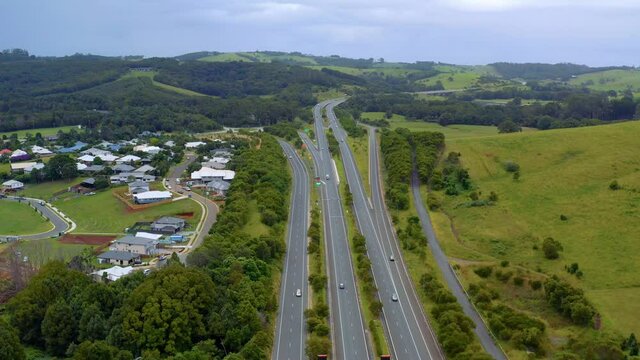 Local–Express Lane System With Cars Passing On Green Hills And Fields At Daytime In Byron Bay, NSW, Australia. - Aerial Drone Shot