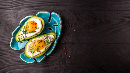 Healthy breakfast. Avocado stuffed with eggs on the table, Delicious breakfast or snack, Long banner format, top view