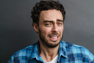 Unshaven scared guy posing and looking at camera