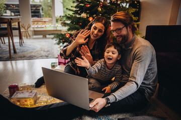 Family having a video call during christmas. - obrazy, fototapety, plakaty