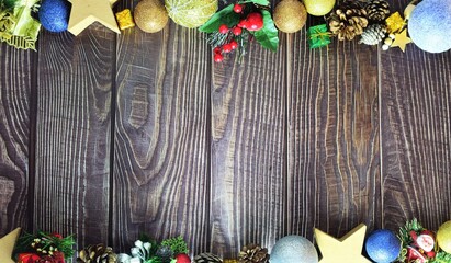 On a rustic wooden table, varied Christmas decorations, with space in the center. Merry Christmas.