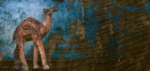 Silhouette of a camel on a blue wooden background. Background of annual rings. Camel for travelers.