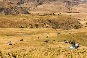 Fototapeta na wymiar Harrismith, South Africa - October 03, 2015: Jeep 4x4 Vehicles on a Dirt Road in the Drakensberg