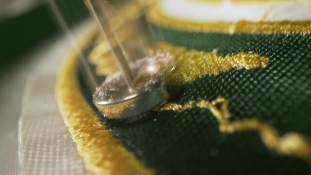 Automated machine embroiders hockey team logo closeup
