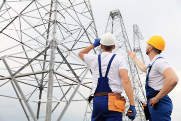 Professional engineers working on installation of electrical substation outdoors
