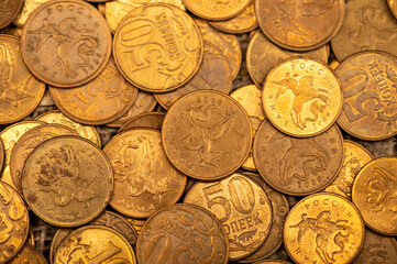 Old coins are scattered on rough sacking. Close up. Background image.