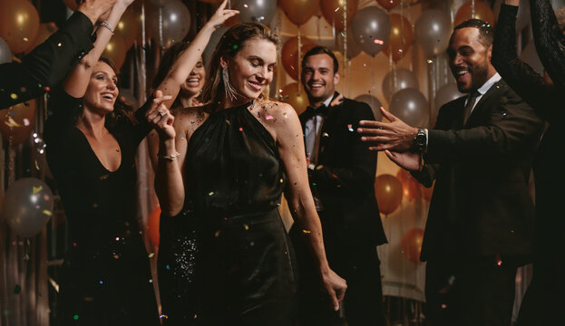Beautiful woman dancing with friends at gala night
