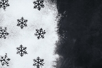 Silhouettes of snowflakes made from flour on a black background copy space. Christmas pastries.