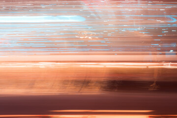 Abstract blue orange light trails in the dark, motion blur effect. Long exposure city lights from the window.