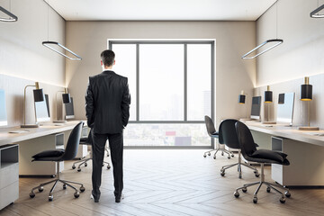 Businessman in office room with computers on table