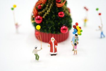 Family Miniature people standing on Christmas tree Celebrate Christmas on December 25 every year. using as background xmas concept with copy spaces for you