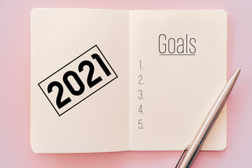 2021 new year goals on notebook with pencil.