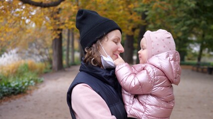 Little Baby Girl And Mother In Medical Mask Outdoors During Coronavirus Outbreak And Quarantine.