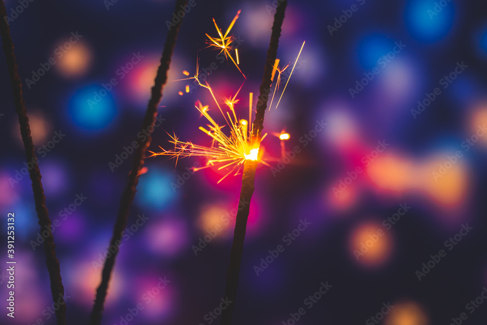 Wall mural conceptual photo of sparklers on beautiful festive blue background with bokeh