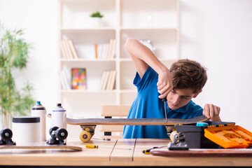 Boy reparing skateboard at home
