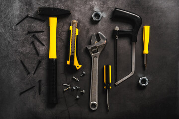 Construction and repair tools on a dark background with space for text