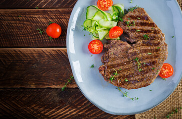Grilled juicy steak medium rare beef with spices and fresh salad. Top view, overhead, flat lay