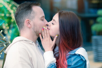 Naklejka premium Stylish caucasian couple in love hugging each other while standing outdoors on the street. Love, relationships, romance, carefree and happiness concept. Copy space.